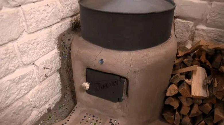 Raketový kámen s dřevem vedle bílé cihlové zdi.