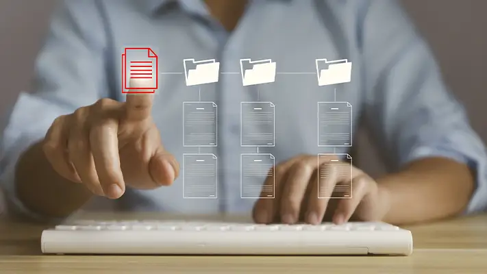 Muž organizuje digitální soubory pro odeslání přes internet.