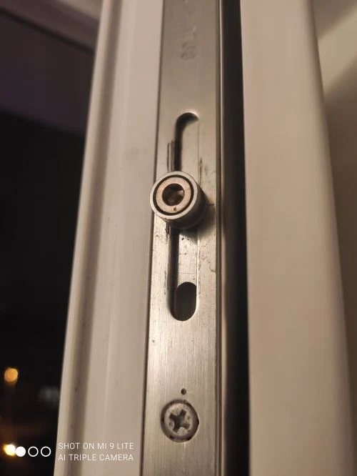 Detail plastového okna s klikou pro opravu zaseknutí.
