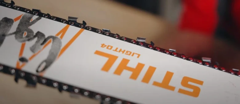 Bílý řezací lišta motorové pily značky Stihl s nasazeným řetězem.