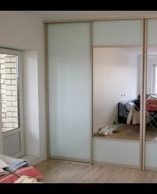 Hotový skříň s posuvnými dveřmi z nábytkových panelů v ložnici.