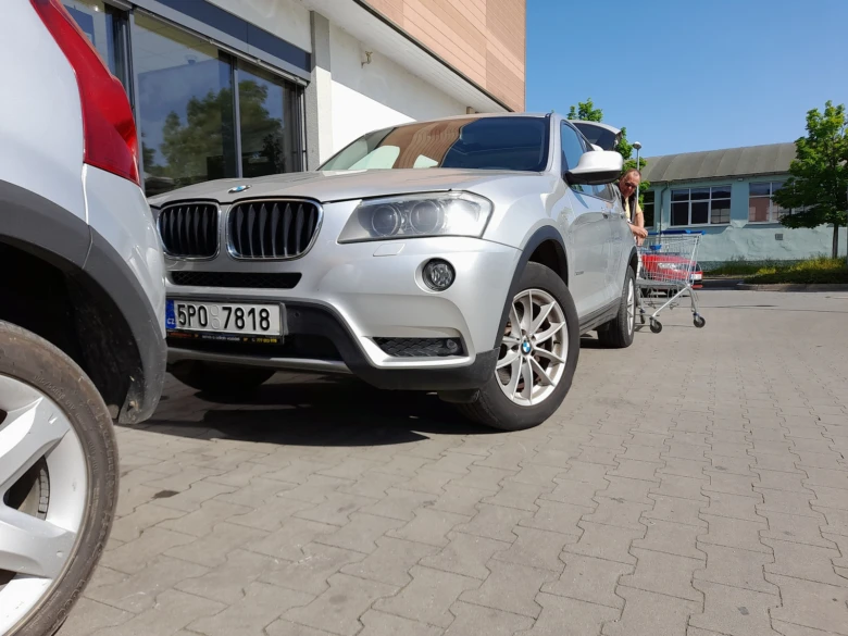 Stříbrný automobil zaparkovaný na parkovacím místě ukazuje jeho rozměry.