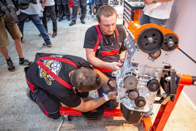 Mechanici pracují na motoru s použitím šroubů.