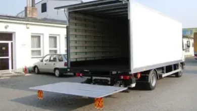 Prázdný nákladní vůz s vytaženou rampou na ulici.