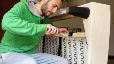 Muž opravuje nábytek šroubovákem pro odstranění vrzání.