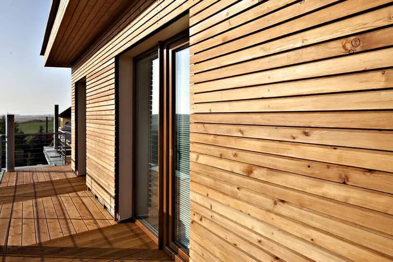Moderní dřevěný dům s impregnovaným obvodem a terasou.