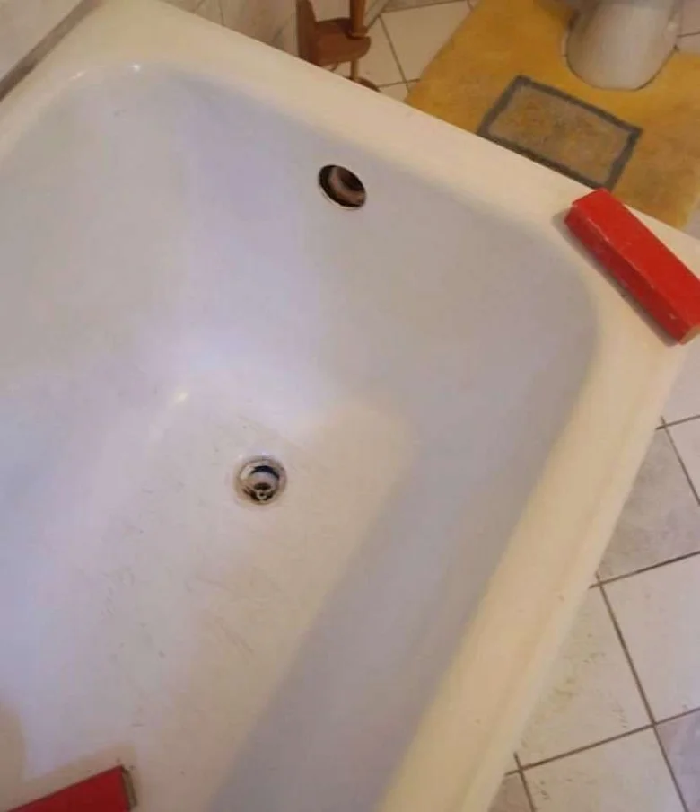 Stará smaltovaná vana s viditelnými škrábanci.
