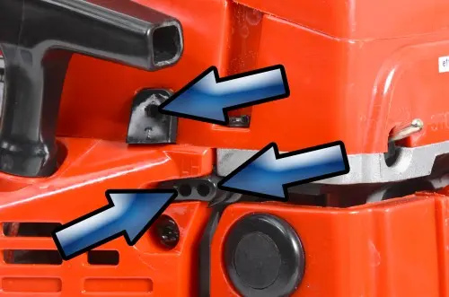 Blízký pohled na motorovou pilu ukazující část filtru a mřížku.