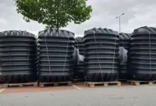 Černé plastové nádrže na paletách venku.