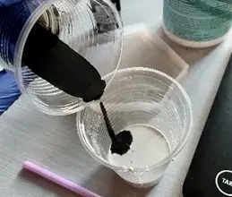 Nalévání černé barvy do bílé směsi pro umělý mramor.
