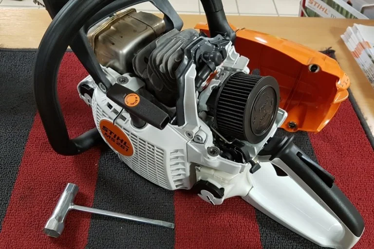 Rozložená motorová pila Stihl s odšroubovaným krytem.