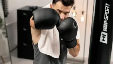 Muž cvičí s boxovacím pytlem v domácím posilovně.