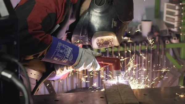 Řezání kovu plazmovou řezačkou s výskytom jisker.