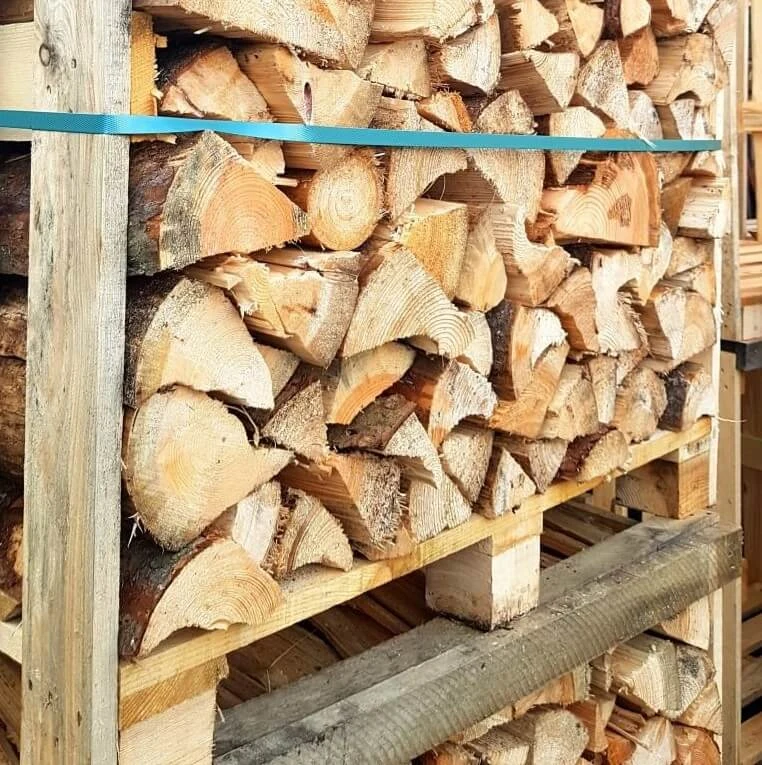 Skládané palivové dřevo v dřevěném rámu pro uskladnění.