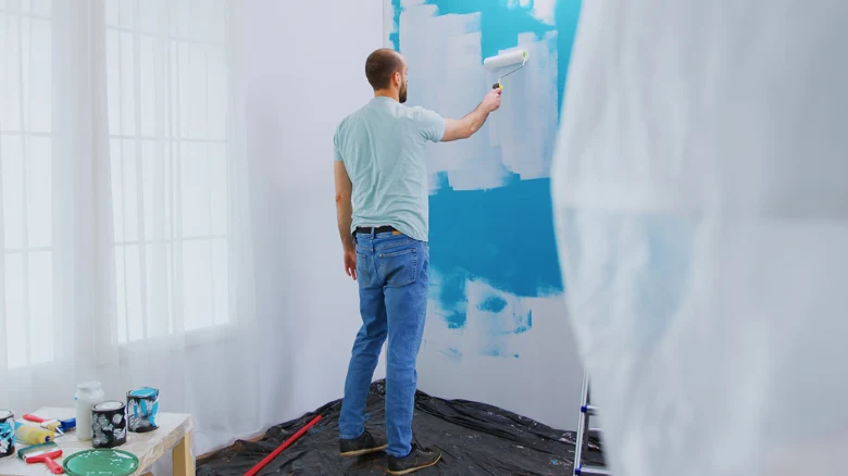 Man painting wall with roller