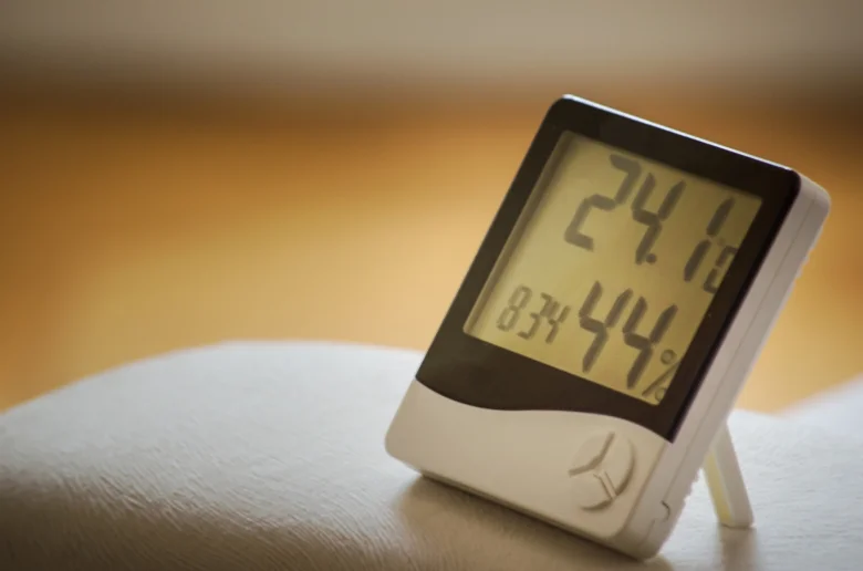 Digitální teploměr s vlhkostí vzduchu na bílém povrchu.