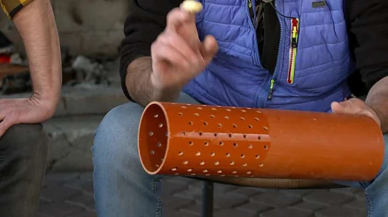 Oranžový vrtaný válec pro lisování pilin na brikety doma.