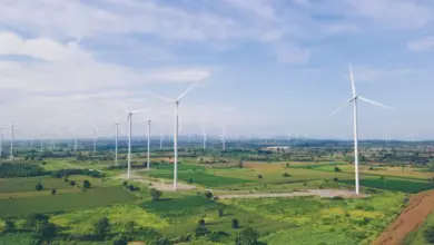 Větrné turbíny na poli jako zdroj obnovitelné energie.