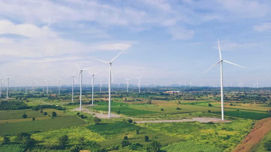 Větrné turbíny na poli jako zdroj obnovitelné energie.