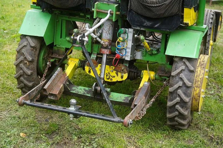Zadní část malého traktoru s hydraulikou a náprvou.