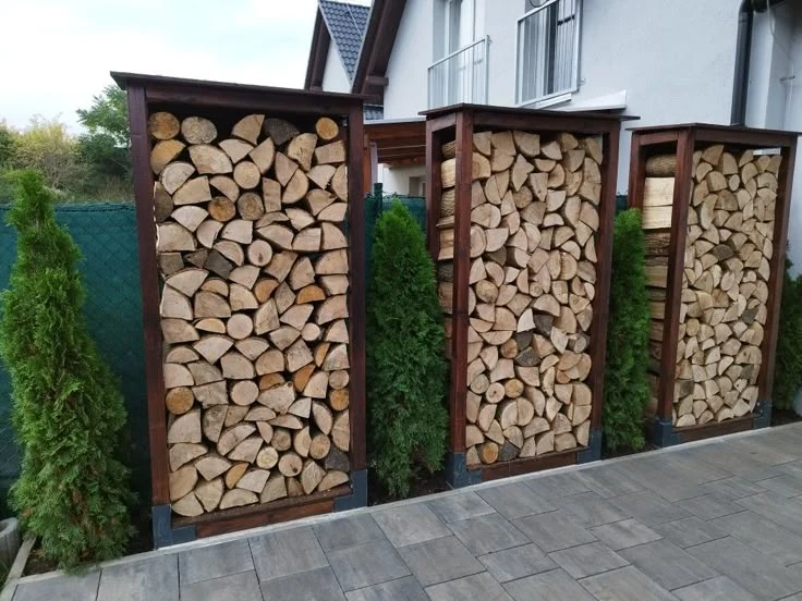 Dřevěné palety s uskladněným palivovým dřívím venku.