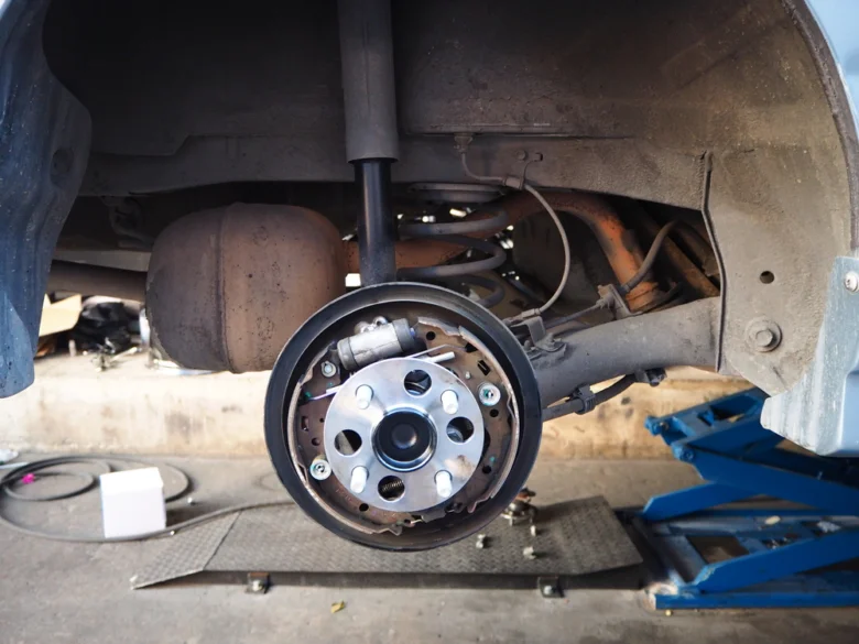 Otevřená bubnová brzda s viditelnými mechanismy pro opravu zaseklé ruční brzdy.