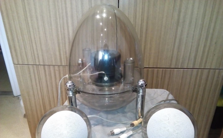 Domácí aktivní subwoofer s reproduktory pod skleněnou koulí.