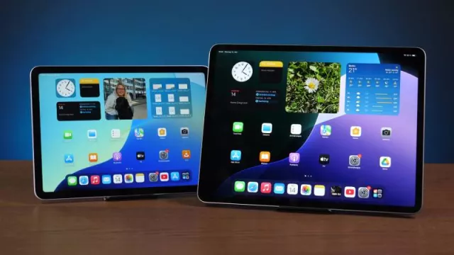 Dva iPady s rozhraním iOS na dřevěném stole.