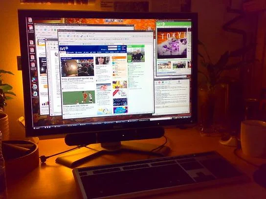 Počítačový monitor na pracovním stole s otevřenými okny prohlížeče.