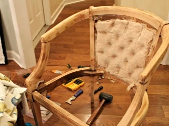 Dřevěný rám židle při opravě s nástroji na podlaze.