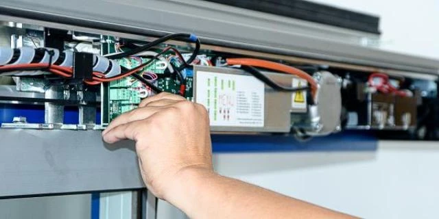 Ruční oprava a údržba vnitřního mechanismu automatických vrat.