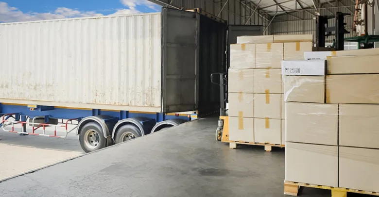 Forklift přenáší palety do kontejneru v skladišti.