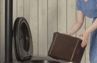 Žena vkládá krabici rašeliny do kompostovací toalety.