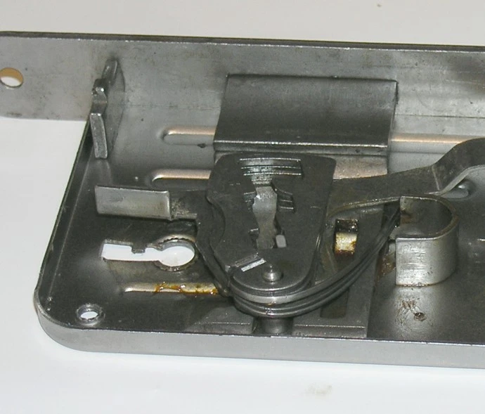 Vnitřní mechanismy zámku s pružinami a pákami pro článek o částech.