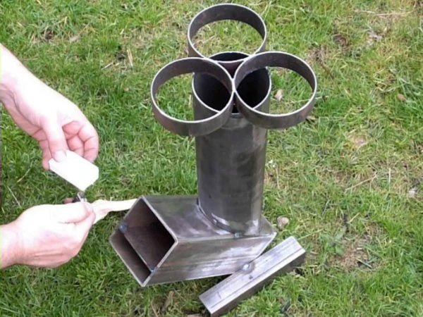 Ruční sestavení raketového kamene z ocelových trubek na trávníku.
