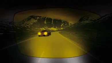 Auto na silnici v noci skrze žluté antireflexní brýle.