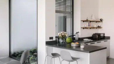 Moderní kuchyňská ostrov s barovými židlemi pro malé prostory.