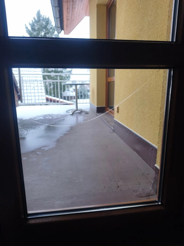 Rozbité sklo v okně domu venku na balkóně.