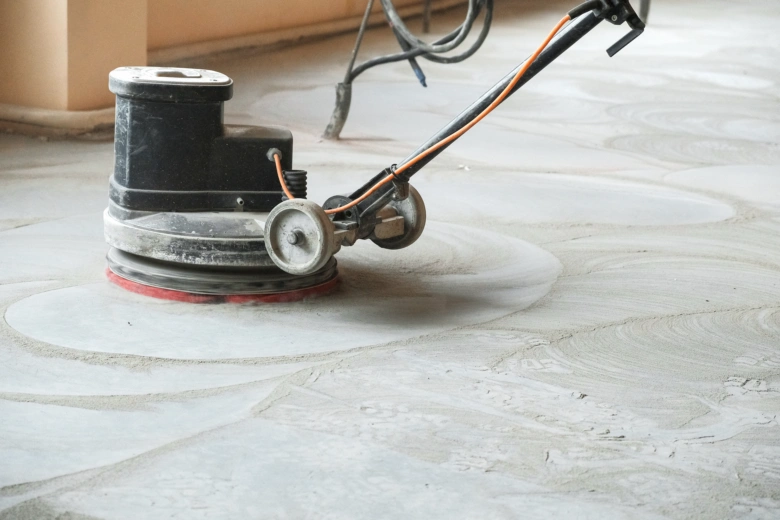 Elektrická bruska pro leštění betonu v akci na podlaze.