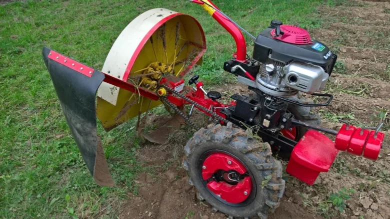 Pojízdný traktor s vyorávačem brambor na poli