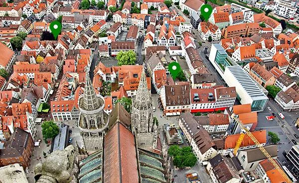 Vzdušný pohled na historické město s kostelními věžemi a červenými střechami.