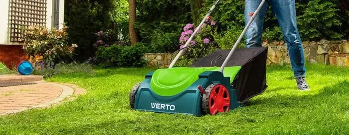 Elektrická sekačka na trávníku v zahradě