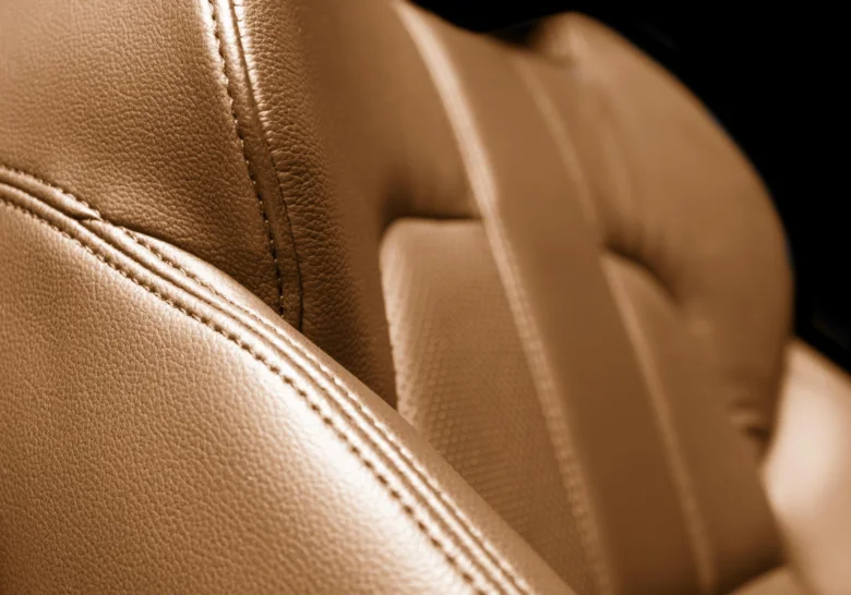 Detail světlé kůže nappa na autosezení s prošitím.