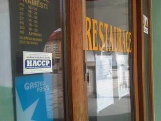 Vchod do restaurace s logem HACCP a nápisem RESTAURACE.