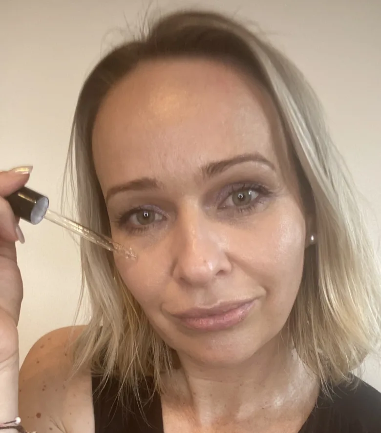 Woman applying serum with dropper