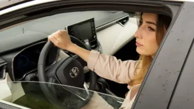 Žena za volantem auta v interiéru při jízdě.