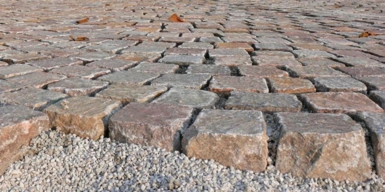 Hotový chodník z přírodního kamene na zahradě s štěrkom.