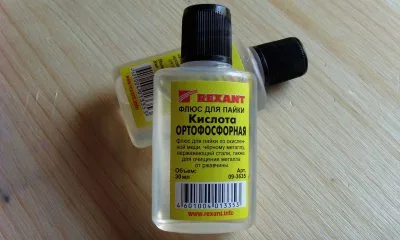 Fialka s kyselinou fosforečnou na dřevěném povrchu.