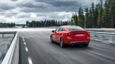 Červené auto jedoucí po dálnici pod mrakem