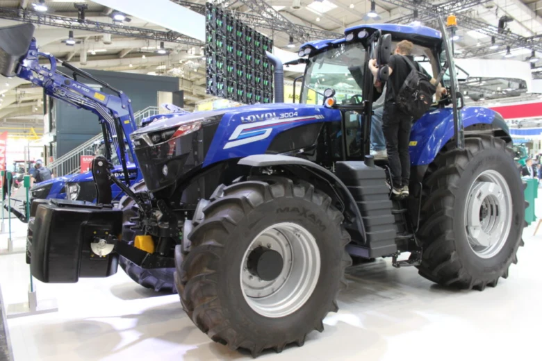 Modrý traktor značky Lovol s předním nakladačem na výstavě.
